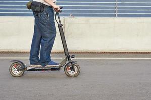 vicino su di uomo guida su elettrico scooter nel il città foto