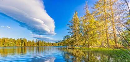 bellissimo presto autunno scena di alto tatra lago. colorato mattina Visualizza di montagne luce del sole, pino foresta alberi, idilliaco cielo riflessione. sorprendente natura paesaggio. escursioni a piedi avventura, bellezza all'aperto foto