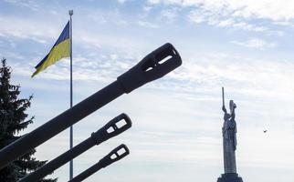 il ucraino bandiera svolazzanti nel il vento, vicino il famoso statua di il patria. il maggiore nazionale bandiera di Ucraina nel il blu cielo. bellissimo autunno paesaggio. Ucraina, kyiv - ottobre 9, 2022. foto
