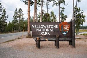 cartello a Ingresso contro alberi a famoso Yellowstone nazionale parco foto