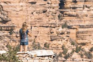 posteriore Visualizza di donna Fotografare roccioso montagna con smartphone foto