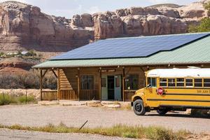 scuola autobus parcheggiata a lavanderia negozio di roccioso montagne foto