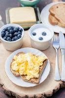 colazione in giardino: uova strapazzate su pane tostato e yogurt foto