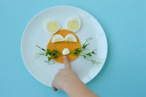 Pasqua prima colazione coniglietto coniglio pranzo piatto, divertimento cibo arte idea per bambini di bollito uovo, pancake e giovane verdi. superiore Visualizza. foto