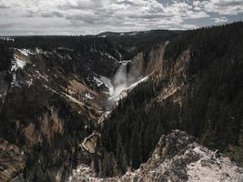 cascata e montagna durante il giorno foto