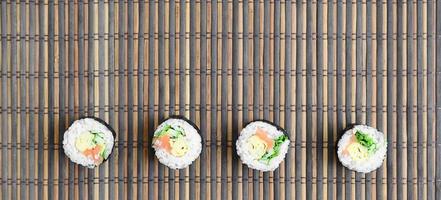 Sushi rotoli bugie su un' bambù cannuccia servire stuoia. tradizionale asiatico cibo. superiore Visualizza. piatto posare minimalismo tiro con copia spazio foto