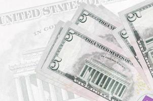 5 noi dollari fatture bugie nel pila su sfondo di grande semi trasparente banconota. astratto presentazione di nazionale moneta foto