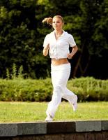 corridore atletico formazione in un parco. ragazza fitness in esecuzione all'aperto