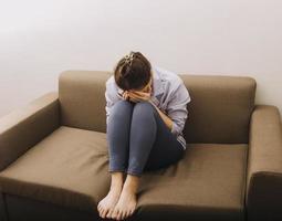 asiatico donne con fatica, lei tenuto se stessa solo nel sua Camera da letto, depressione. foto