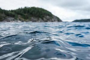 mare onde su il acqua, contro il sfondo di rocce e il cielo è su di messa a fuoco. parte inferiore Visualizza. foto