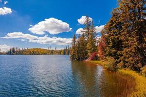 autunno tramonto paesaggio con tranquillo tranquillo, calmo montagna lago. quiete natura nel autunno stagione. nebbioso lago Alba con autunno fogliame e montagne, sorprendente nuvole cielo. fantasia natura fogliame foto