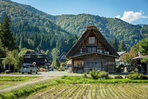 giapponese shirakawago villaggio durante ottobre nel autunno autunno fogliame stagione. shirakawa tradizionale Casa su triangolo tetto con un' sfondo di riso campo, pino montagna e chiaro nube cielo dopo. foto