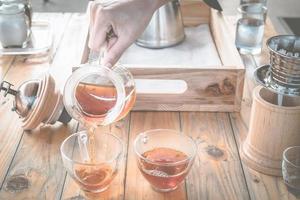 barista scrosciante un' caldo caffè dopo tuffo caffè nel un' bicchiere tazza di caffè. foto