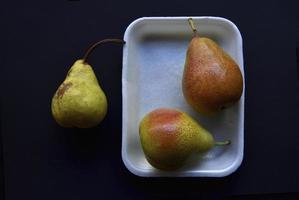 rosso e verde pere su un' nero sfondo. pere nel un' pacchetto a partire dal il negozio. bellissimo frutta di pere. foto