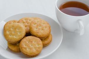 Sandwich crema cracker con caldo tè per rottura tempo foto