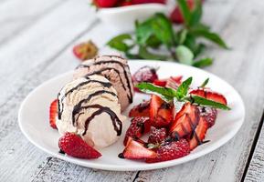 gelato con fragole e cioccolato su un piatto bianco foto