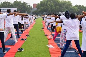 gruppo yoga esercizio sessione per persone di diverso età gruppi a cricket stadio nel delhi su internazionale yoga giorno, grande gruppo di adulti frequentando yoga sessione foto