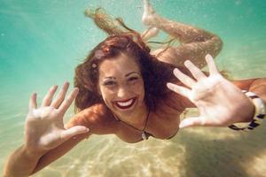 carino ragazza nuoto sotto mare foto