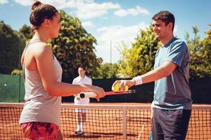 giovane coppia preparazione per servire su tennis incontro foto