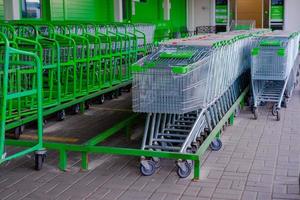 parcheggio per shopping cesti. shopping nel il supermercato. parcheggiata cesti.vuoti parcheggio quantità. cesti di diverso taglie. shopping cesti per prodotti nel supermercato foto