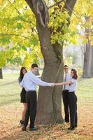 giovane attività commerciale persone abbracciare albero foto