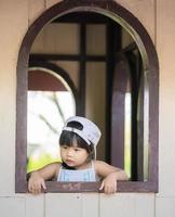 bambina in piedi vicino alla finestra foto