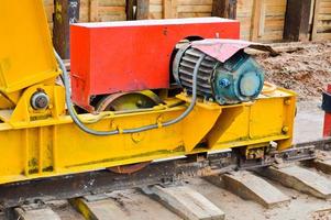 grande ferro metallo giallo supporti su rotaie con ruote con un induzione il motore di un' grande costruzione stazionario industriale potente cavalletto gru di un' ponte genere foto