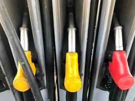 Riempimento colorato pistole a un' gas stazione per rifornimento carburante un' auto con carburante, benzina, diesel foto