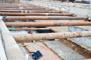 un' grande enorme fosso fossa tunnel con rafforzando strutture a partire dal di spessore ferro tubi di travi e strutture a il costruzione luogo di il metropolitana la metropolitana stazione linea foto