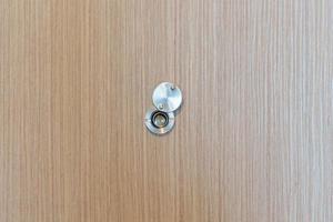 lente spioncino su legna porta nel appartamento camera. sicurezza concetto foto