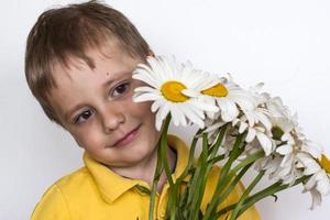 un' carino ragazzo con un' bellissimo mazzo di grande margherite. ritratto di un' bambino, divertente e carino facciale espressione. selettivo messa a fuoco. foto