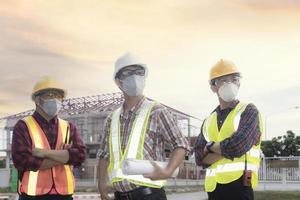 squadra ingegneri e lavoratore di tre luogo costruzione su sfondo foto