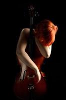 giovane donna appoggiata al violoncello foto