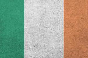 Irlanda bandiera raffigurato nel luminosa dipingere colori su vecchio sollievo intonacatura parete. strutturato bandiera su ruvido sfondo foto