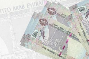 500 Emirati Arabi Uniti dirham fatture bugie nel pila su sfondo di grande semi trasparente banconota. astratto presentazione di nazionale moneta foto