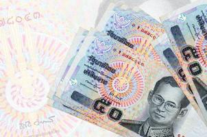 50 tailandese baht fatture bugie nel pila su sfondo di grande semi trasparente banconota. astratto presentazione di nazionale moneta foto