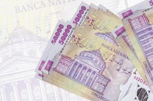 50000 rumeno leu fatture bugie nel pila su sfondo di grande semi trasparente banconota. astratto presentazione di nazionale moneta foto
