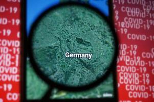 Germania nazione su Google mappe sotto ingrandimento bicchiere con rosso covid-19 testo sfondo. selettivo messa a fuoco. foto