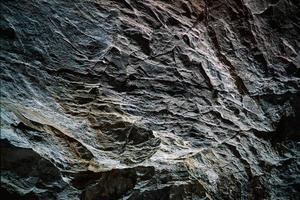 parete rocciosa grigia e nera foto