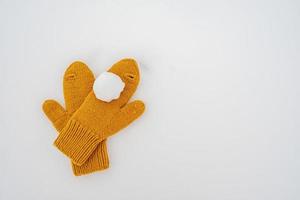 palla di neve su giallo a maglia guanti, nel il neve. inverno attivo Giochi e intrattenimento. copia spazio. foto