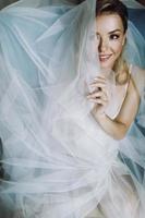 splendida sposa bionda con occhi profondi nascosti sotto un velo blu