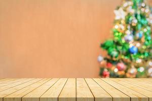 vuoto legna tavolo superiore con sfocatura Natale albero con bokeh leggero sfondo foto