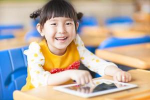 bambino sorridente utilizzando tablet o ipad foto