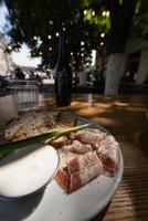 vicino su Visualizza fette di affumicato Bacon carne con segale totale grano nero pane, verde cipolla e acida crema su il tavolo. foto
