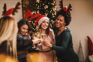 quattro multietnico femmina amici fabbricazione crostini come e avendo divertimento durante Natale festa a casa foto