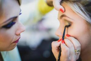 trucco artista l'applicazione ombretto su un' ragazza foto