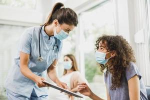 africano americano ragazza parlando per infermiera prima covid-19 vaccino foto