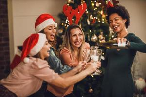 quattro multietnico donna avendo divertimento e rendere crostini come essi celebrare a casa Natale festa foto