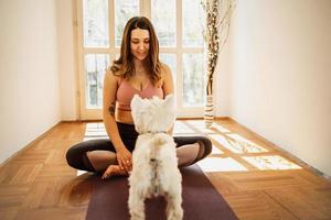 donna fare yoga con sua cane foto