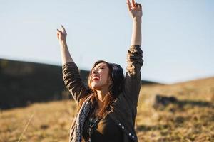 donna ascoltando musica e avendo divertimento su il prato foto